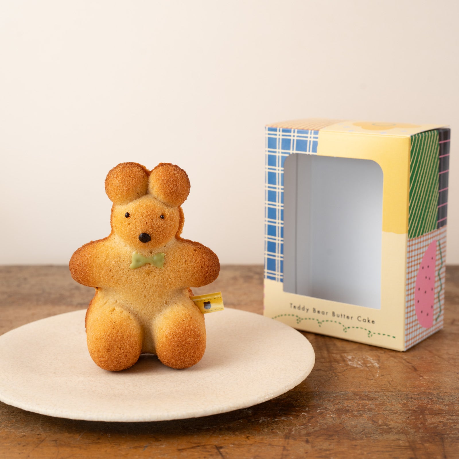 緑のリボンをした座っているテディベアのケーキ