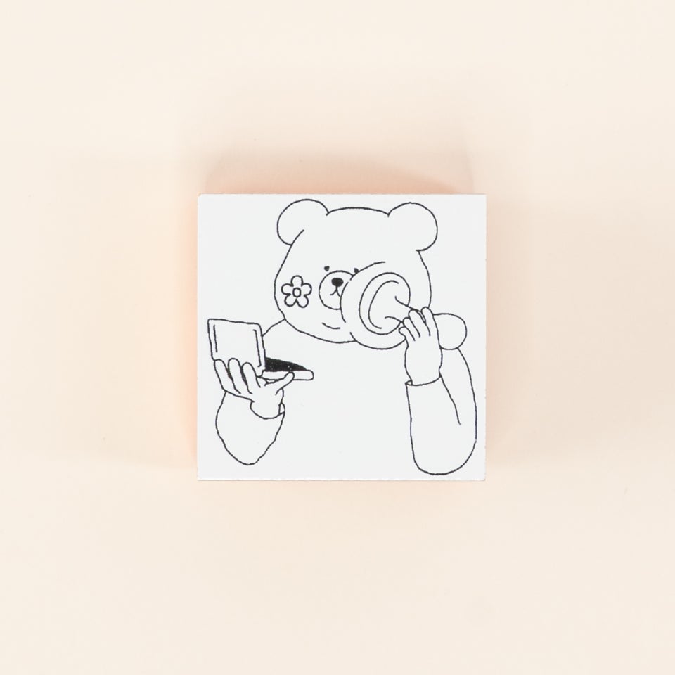 クマが顔にスタンプを押しているかわいいデザイン